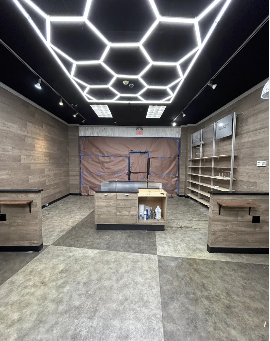 Wide view of completed barber shop commercial interior with geometric ceiling lighting