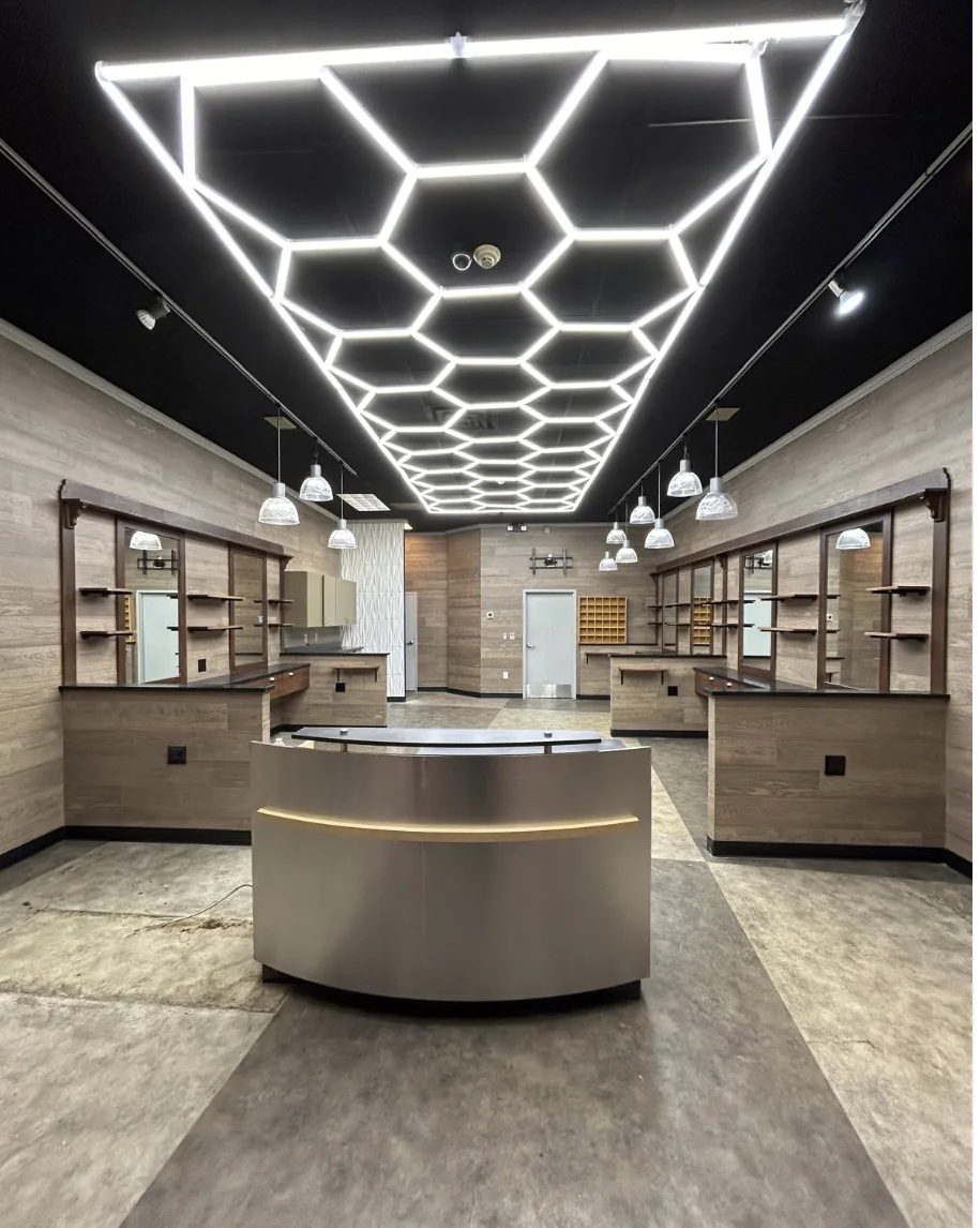 Completed barber shop commercial build-out by HQ Construction & Remodeling with custom stations, reception counter and geometric ceiling lighting